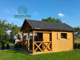domek letniskowy z dachem czarnym i tarasem malym na kamieniach