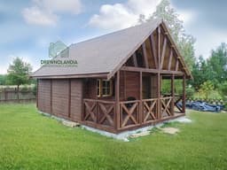 duży piętrowy domek letniskowy stojący na trawie na tle drzew