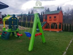 Drewniany domek z placem zabaw dla dzieci – idealny do zabawy w ogrodzie