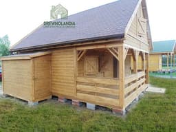 brazowy domek letniskowy z ciemnym dachem na trawie